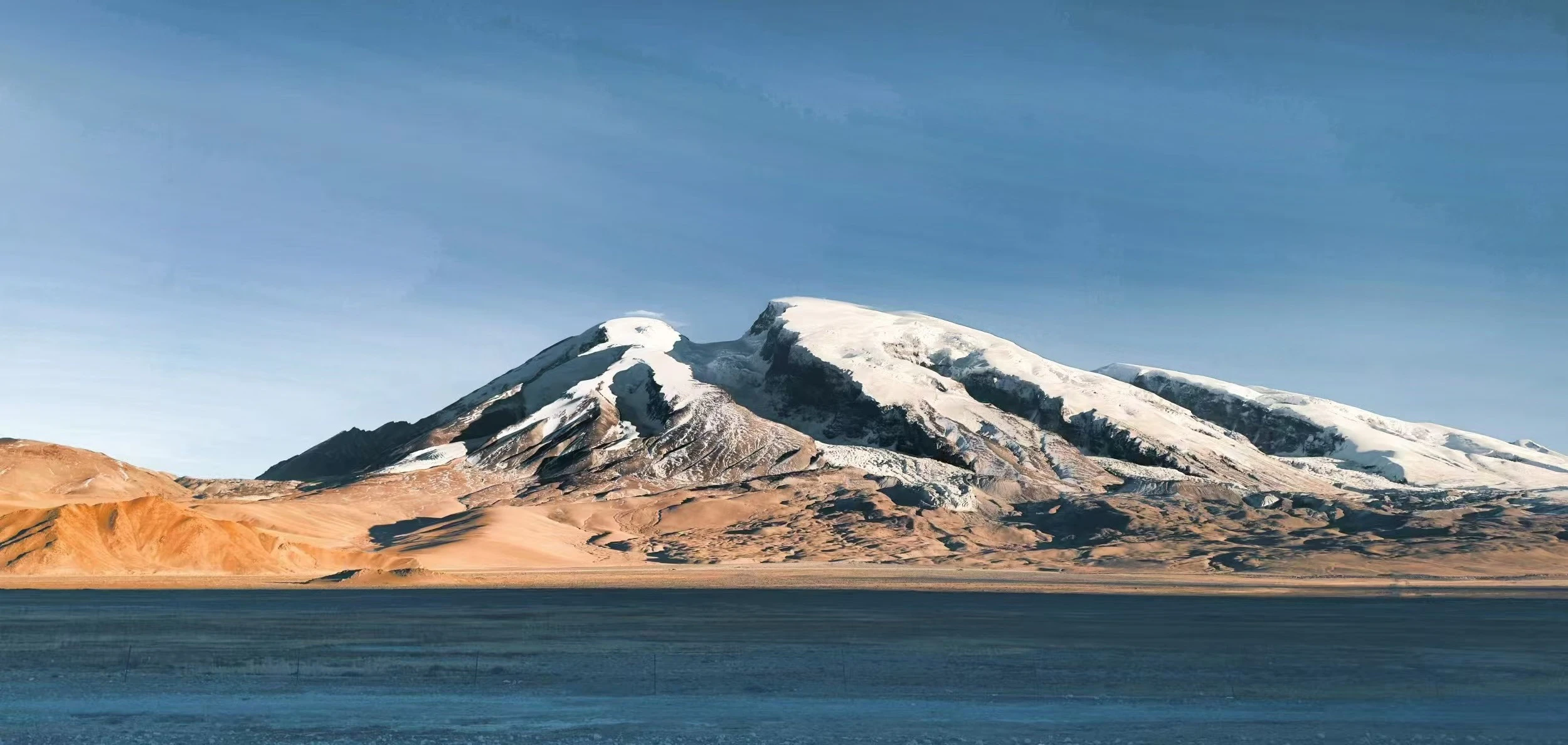 Muztagh Ata rising above the broad Pamir road corridor in Xinjiang