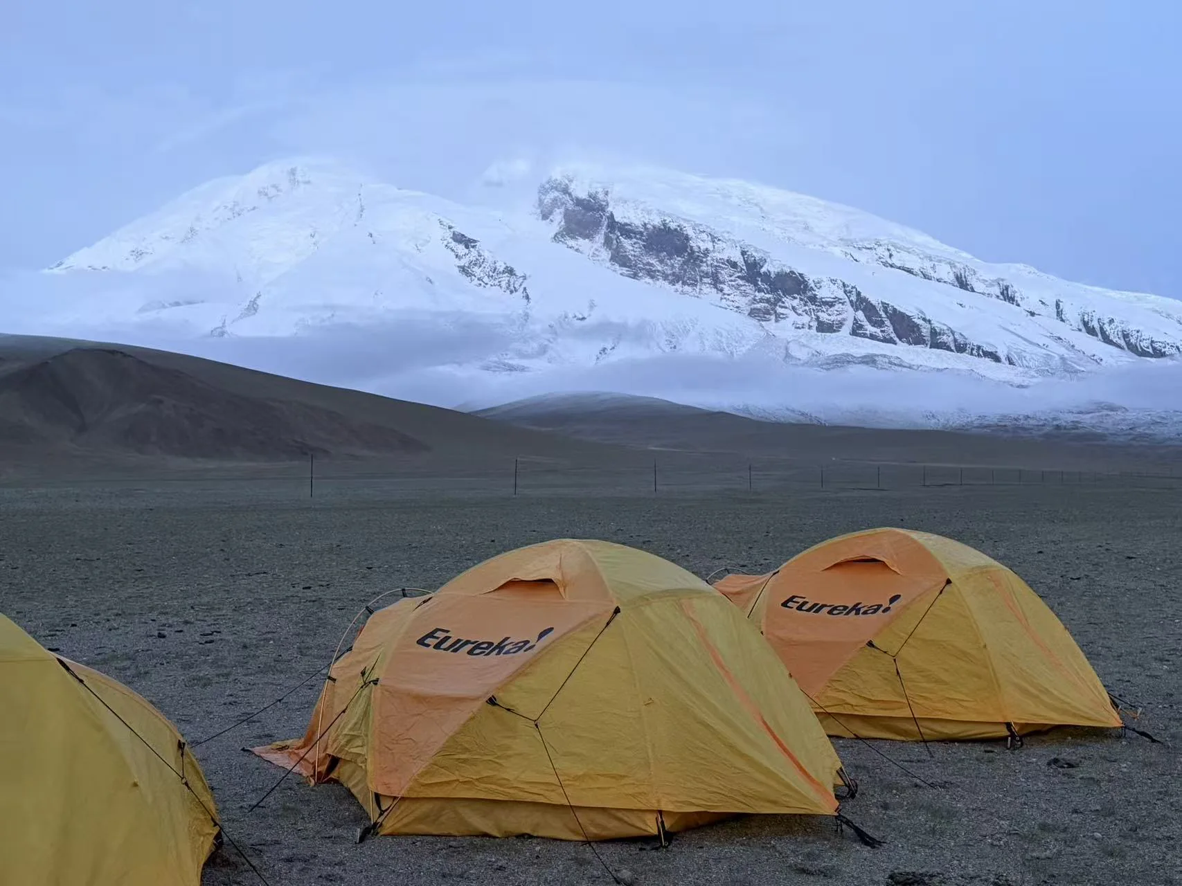 Yellow tents at Subashi, also known as 204, below the glacier-covered face of Muztagh Ata.
